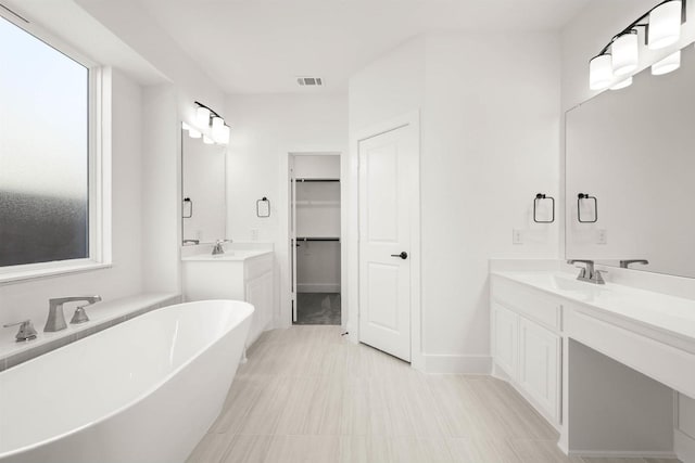 bathroom with vanity and a washtub