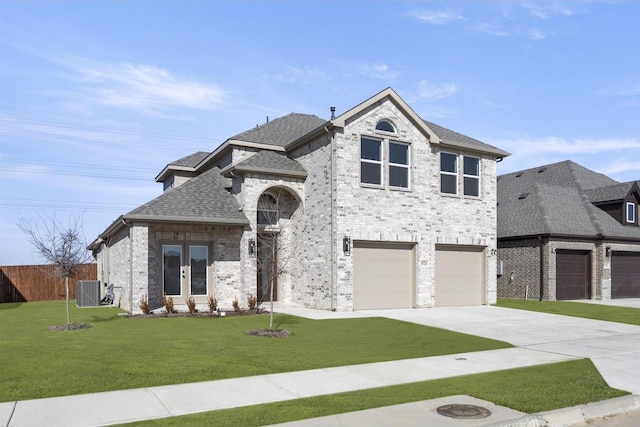 view of front facade with a garage, central AC, and a front lawn