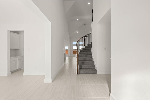 stairway featuring high vaulted ceiling