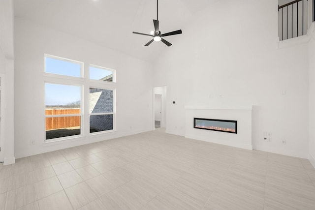 unfurnished living room featuring ceiling fan and high vaulted ceiling