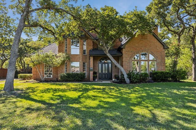 tudor-style house featuring a front lawn