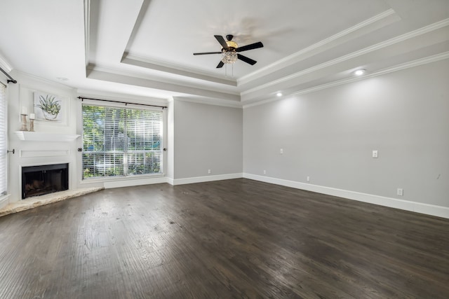 unfurnished living room featuring dark hardwood / wood-style floors, a tray ceiling, and crown molding