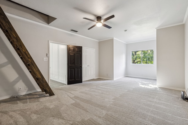 unfurnished room with crown molding, ceiling fan, and light colored carpet