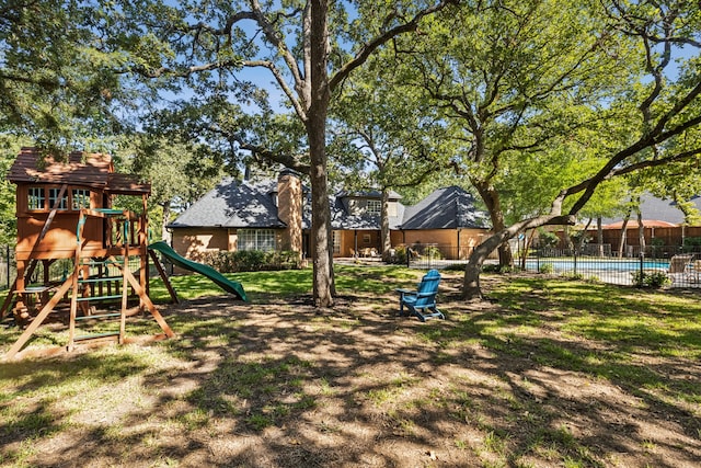 view of jungle gym featuring a fenced in pool and a lawn