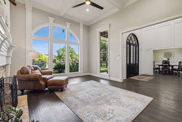 living room with ceiling fan, beamed ceiling, dark hardwood / wood-style floors, and ornamental molding