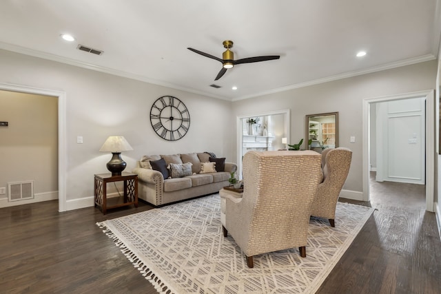 living room featuring ornamental molding, ceiling fan, and dark wood-type flooring