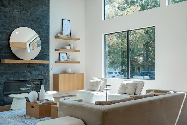 living room featuring hardwood / wood-style floors, a high ceiling, and a high end fireplace