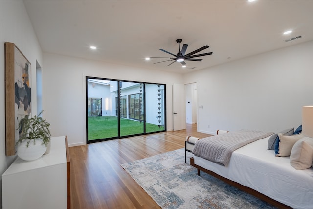 bedroom featuring access to outside, hardwood / wood-style flooring, and ceiling fan