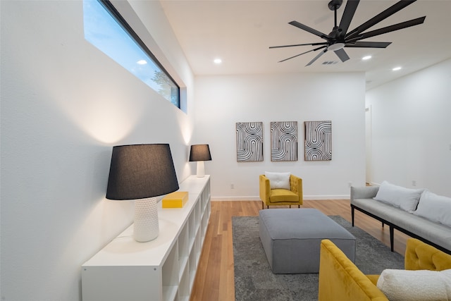 living room featuring wood-type flooring and ceiling fan