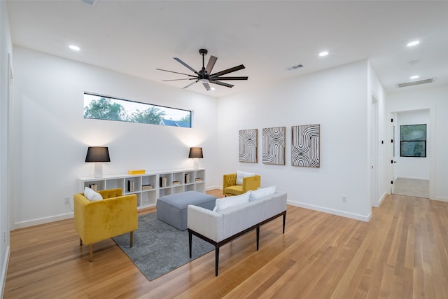 living room with ceiling fan and light hardwood / wood-style flooring