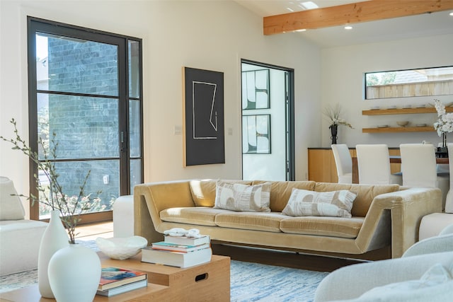 living room featuring beamed ceiling and a healthy amount of sunlight