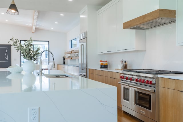 kitchen with custom exhaust hood, light hardwood / wood-style floors, white cabinetry, light stone countertops, and high quality appliances