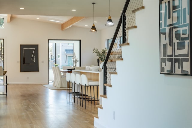 dining space featuring lofted ceiling with beams and light hardwood / wood-style flooring