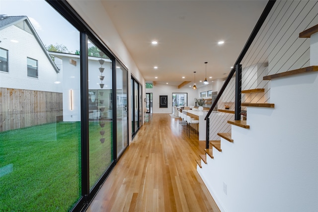 hallway with a wall of windows and light wood-type flooring