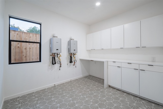 laundry area featuring light tile patterned floors and tankless water heater