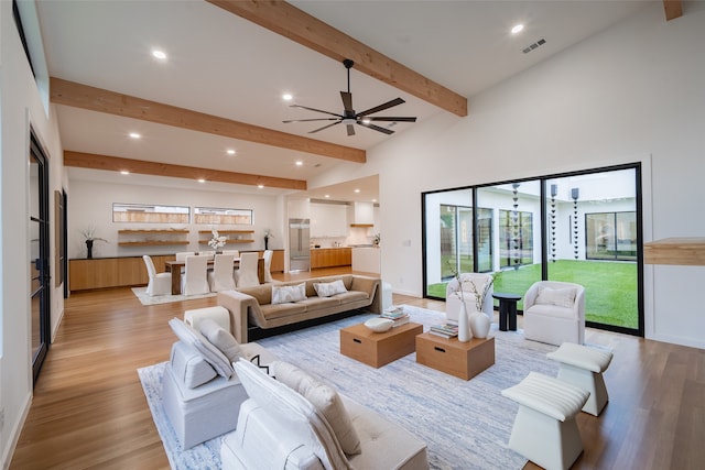 living room with ceiling fan, light wood-type flooring, high vaulted ceiling, and beam ceiling