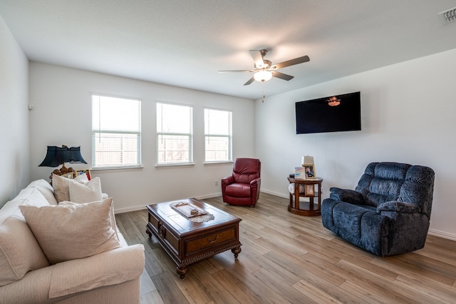 living room featuring light wood-type flooring and ceiling fan