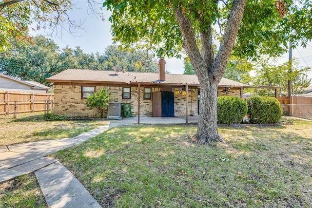 view of front of property with a front yard, a patio, and central air condition unit