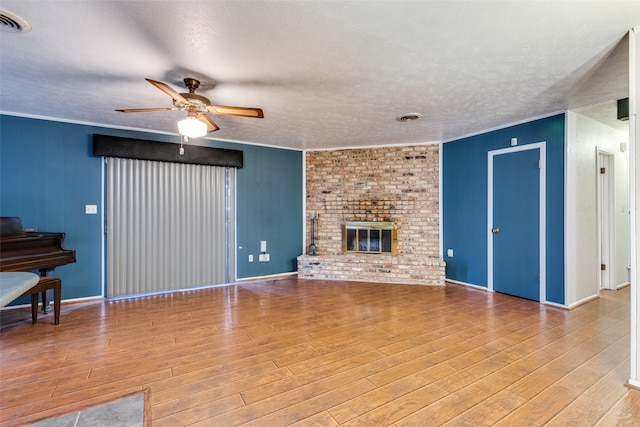 living room featuring light wood-type flooring, ceiling fan, and a fireplace