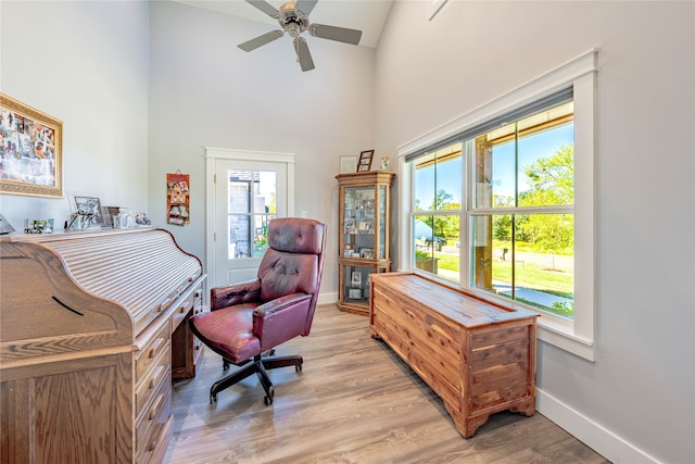 office space with ceiling fan, light hardwood / wood-style floors, and high vaulted ceiling