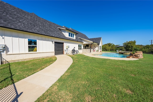 rear view of property featuring a patio, a yard, and a fenced in pool