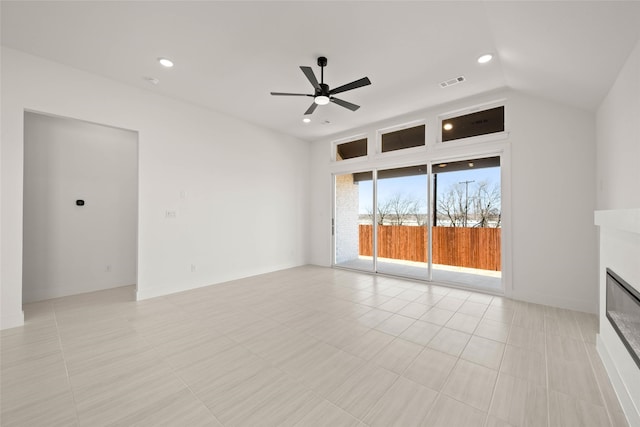 unfurnished living room featuring ceiling fan, vaulted ceiling, and light tile patterned floors