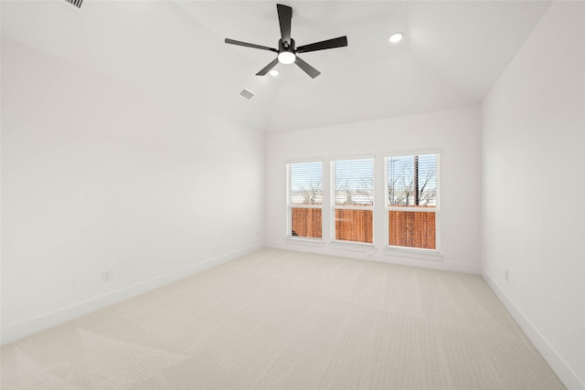 empty room featuring vaulted ceiling, light colored carpet, and ceiling fan