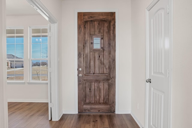 entryway with baseboards and wood finished floors