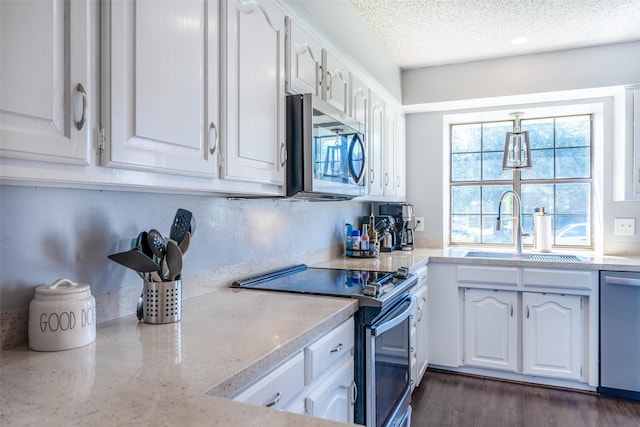 kitchen featuring sink, a textured ceiling, white cabinets, and stainless steel appliances