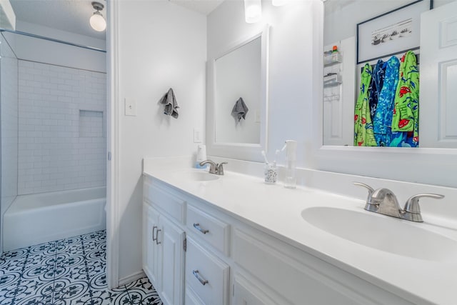 bathroom with a textured ceiling, tile patterned flooring, tiled shower / bath, and vanity