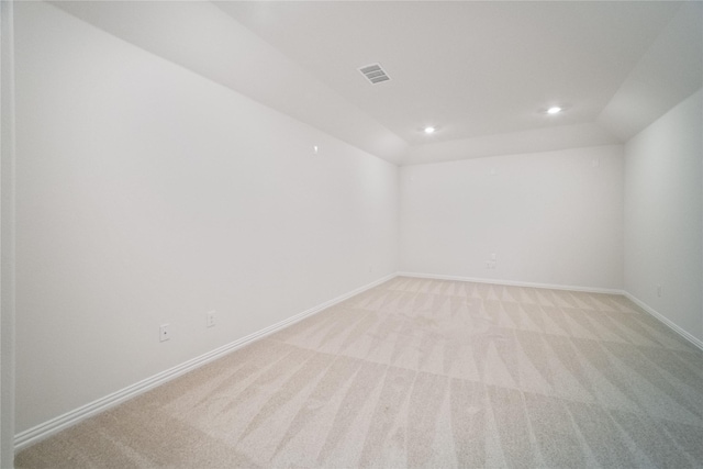 spare room featuring visible vents, baseboards, light colored carpet, vaulted ceiling, and recessed lighting