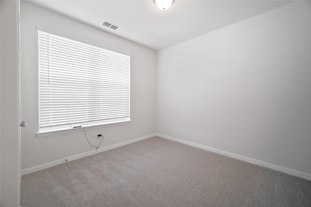 carpeted empty room with baseboards and visible vents