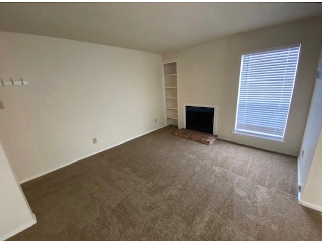 unfurnished living room with dark carpet and a fireplace