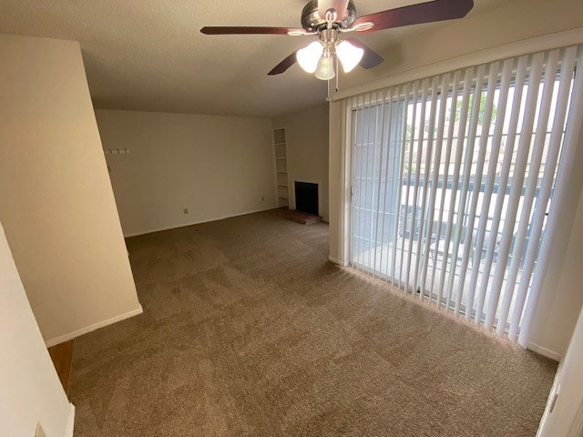 carpeted spare room with ceiling fan