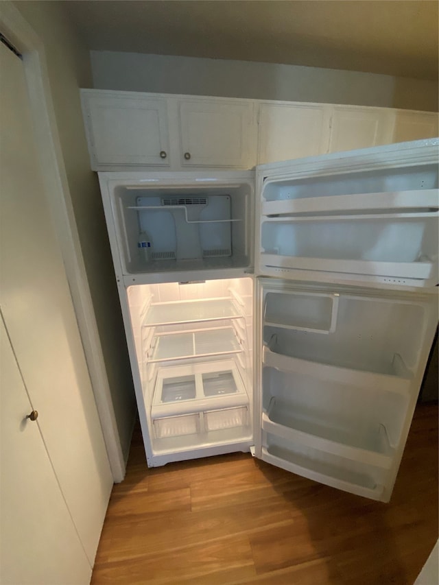 interior space with white cabinets, light hardwood / wood-style floors, and white fridge