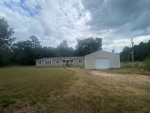 view of front of home with a front lawn, an outdoor structure, and a garage