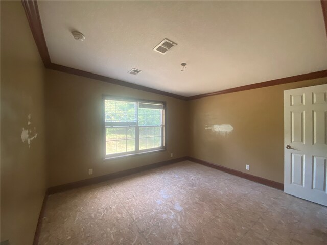 spare room featuring ornamental molding and vaulted ceiling