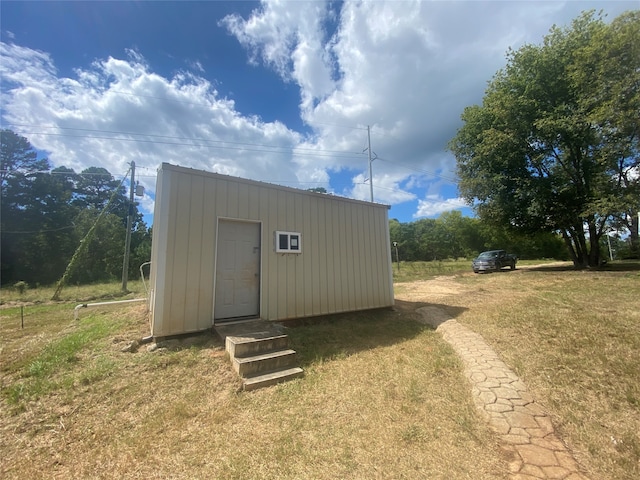 view of outbuilding featuring a lawn