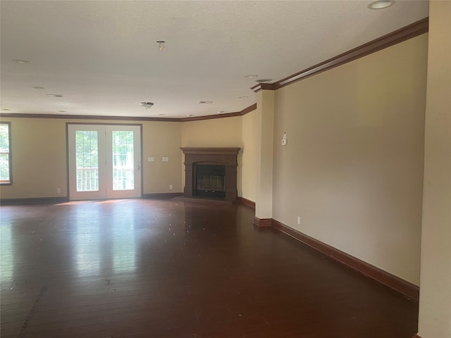 unfurnished living room with a healthy amount of sunlight, crown molding, and dark wood-type flooring