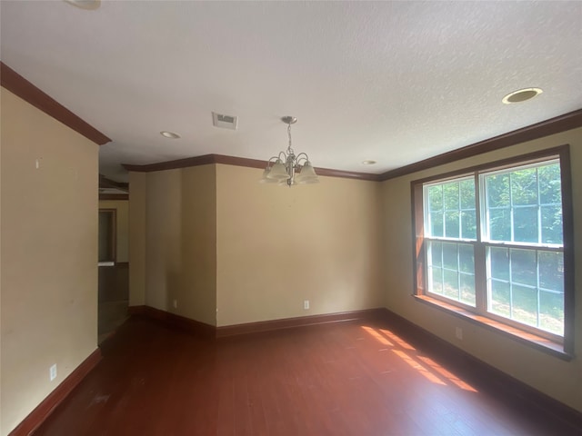 spare room with a chandelier, a textured ceiling, crown molding, and dark hardwood / wood-style flooring