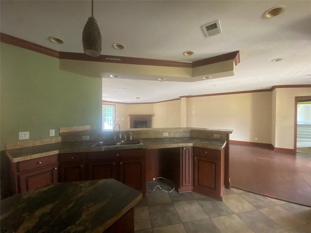 kitchen with crown molding, sink, and pendant lighting