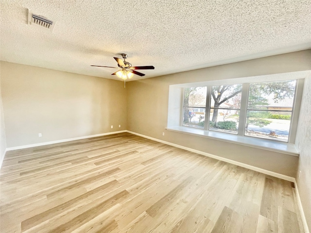 spare room with light wood-type flooring, a textured ceiling, and ceiling fan