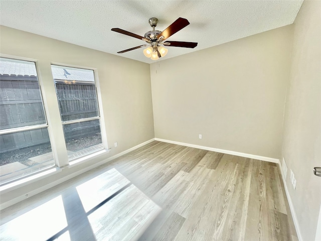 unfurnished room featuring a textured ceiling, ceiling fan, and light hardwood / wood-style flooring