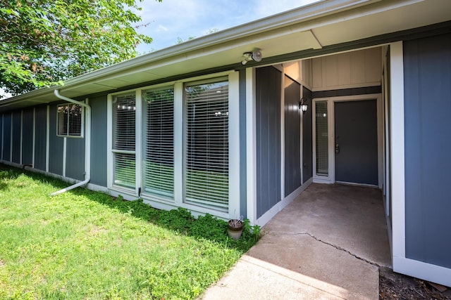 view of exterior entry featuring a yard