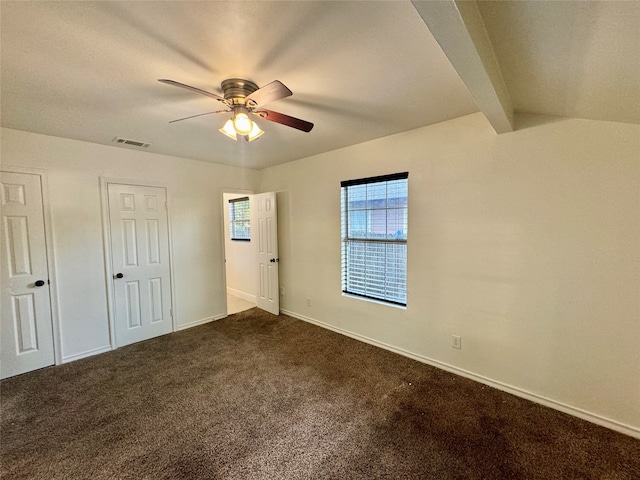 unfurnished bedroom with vaulted ceiling with beams, ceiling fan, and dark carpet