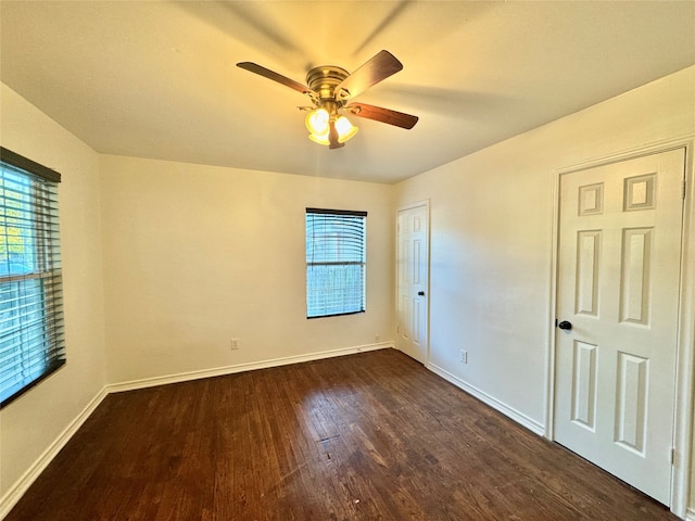 empty room featuring dark wood-type flooring and ceiling fan