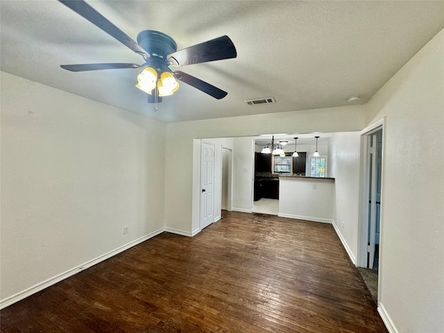 unfurnished bedroom with a closet, ceiling fan, dark hardwood / wood-style floors, and a textured ceiling