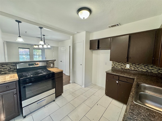 kitchen with dark brown cabinetry, hanging light fixtures, an inviting chandelier, stainless steel range with gas cooktop, and decorative backsplash