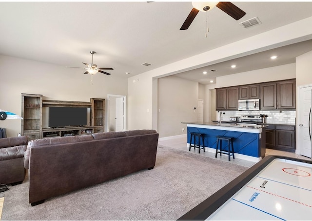 living room featuring ceiling fan and sink