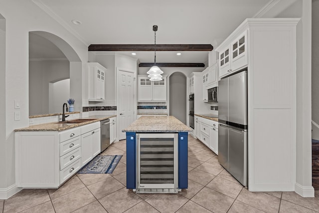 kitchen with stainless steel appliances, white cabinets, and beverage cooler